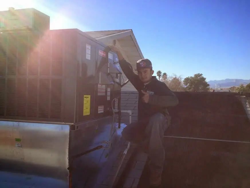 HVAC technician performing AC Tune-Up on a rooftop unit in Bound Brook